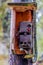 Image of an old dirty control box with cobwebs on a wooden pole