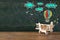 Image of old wooden airplane toy on wooden table in front of set of info graphics over textured chalkboard