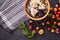 Image of orange plate of oatmeal with blueberries and bananas stands on delicate black wooden background on which lies checkered