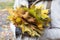 Image of part girl with bouqet of colorful maple leaves.