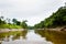 Image in Peruvian jungle, close to amazon river. Calm water, trees, wood.