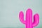 Image of pink neon cactus decoration infront of wooden blue background.