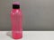Image of pink water bottle by Tupperware brand isolated on grey background.