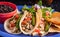 Image of a plate of tacos with salad and black beans