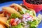 Image of a plate of tacos with salad and black beans