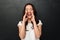 Image of pleased asian woman in casual t-shirt shouting or calling putting hands at mouth, isolated over dark gray background