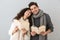 Image of pleased couple man and woman reading books together, isolated over gray background