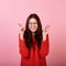 Image of a pretty brunette woman in with a vitra praying with crossed fingers and looking up over a pink background