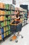 Image of pretty woman with cart choosing products in supermarket