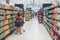 Image of pretty woman with cart choosing products in supermarket