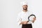 Image of professional chief man in cook uniform smiling and holding frying pan