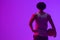 Image of rear view of biracial basketball player with basketball on neon purple background