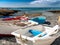 Image of recreational wooden rowing boats on the rocky beach at ocean shore