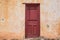 Image of red door on old abandoned house