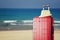 Image of red elegant travel luggage and fedora hat in front of sea. travel and vacation concept