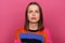 Image of sad depressed stressed woman wearing colorful jumper posing isolated over pink background, looking at camera with pout