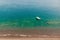 Image of sandy shore, sailing boat, azure sea.