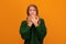 Image of scared blonde teen covering her mouth with hands. Fright, horror concept. Studio shot, yellow background