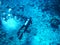 image of scuba diver swimming underwater at the bottom of the sea with lots of air bubbles