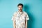 Image of shocked tourist guy drop jaw, gasping and looking startled, standing in hawaiian shirt on blue background