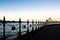 The image shows the view of Sydney harbour and Sydney Opera house from sidewalk under the harbour bridge at twilight time sky.