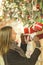 Image on side of happy woman with glass in hands near boxes with gifts ,decorated spruce branches