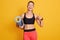 Image of slim beautiful woman ready for workout with yoga mat and thumbs up, sporty female looks laughing at camera and showing ok