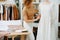 Image of a small business. She tries on a dress on a mannequin