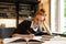 Image of smart teenage girl studying, while sitting at desk in c
