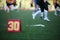 Image of soccer field with number thirty running football players on blurred background