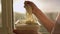 A image of someone eating instant noodles at home by the window in the kitchen,