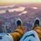 image of someone sitting on high area with bird\\\'s eye view looking down on the landscape below with a pair of legs in view