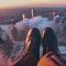 image of someone sitting on high area with bird\\\'s eye view looking down on the landscape below with a pair of legs in view