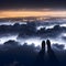 image of someone sitting on high area with bird\\\'s eye view looking down on the landscape below with a pair of legs in view