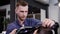 Image of stylish male barber using hairdryer for making modern haircut in barbershop. Young man is blowing dry client`s