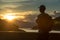 Image of sunrise with a silhouette of a tourist man in natural surrounding