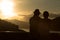 Image of sunset on orange and yellow horizon with a silhouette of a senior couple in natural surrounding