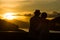 Image of sunset on orange and yellow horizon with a silhouette of a senior couple in natural surrounding