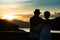 Image of sunset on orange and yellow horizon with a silhouette of a senior couple in natural surrounding