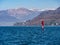 Image of surfer on the lake maggiore with city and alps with snow peaks in the background