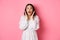 Image of surprised korean girl in dress, female model staring at camera and gasping amazd, standing over pink background