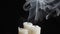 Image of three smouldering candles on black background