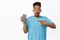 Image of thrilled african american guy pointing finger at smartphone screen, empty mobile phone display, gasp amazed and