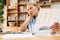 Image of tired blonde woman working with papers and laptop