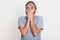 Image of tired sleepy bearded young man standing isolated over white background in studio, yawning in morning, covering his mouth