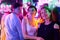 Image of two beautiful women and one man in an amusement park in a room with neon light. Entertainment concept