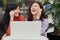 Image of two emotional positive cute sweet friends having lunch, sitting at cafe, laughing sincerely, closing eyes, using white