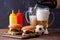 Image of two hamburgers, glasses, soccer ball, ketchup