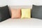 Image of two yellow and orange small pillows between two black big pillows.