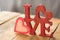 Image of Valentine`s Day, symbols of love and letters, on a background of wooden boards.